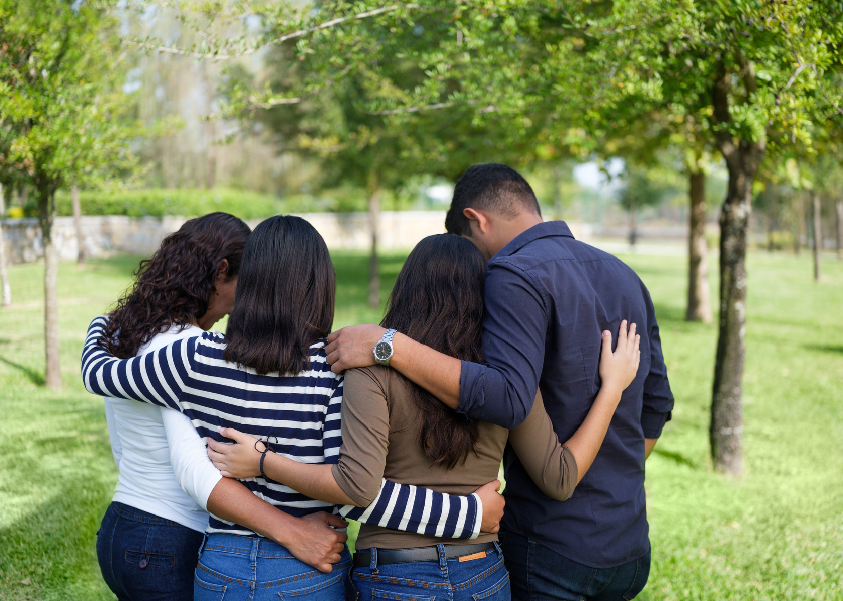 Back view of latin family praying together